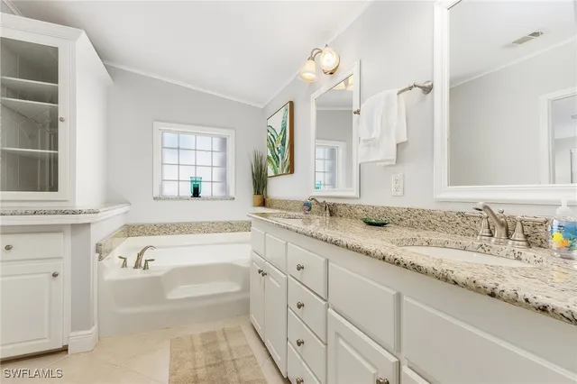 a spacious bathroom with a granite countertop sink mirror and bathtub