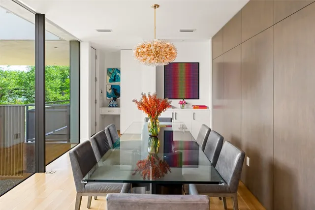 a view of a dining room with furniture a potted plant and wooden floor