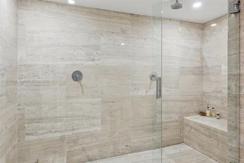 a view of a hallway with wooden floor and a bathroom