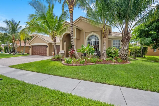 a front view of a house with a garden and plants