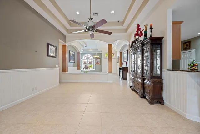 a view of a hallway with windows and chandelier