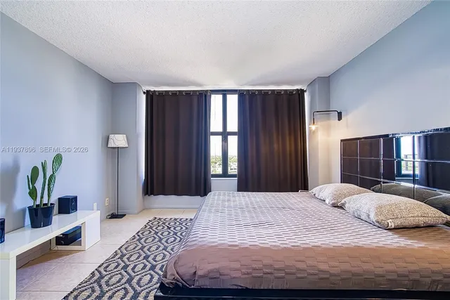 a bathroom with a granite countertop sink a toilet a mirror and shower