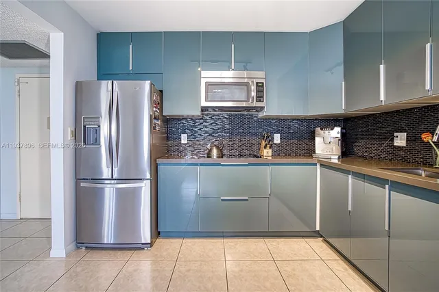 a kitchen with stainless steel appliances granite countertop a refrigerator and a stove