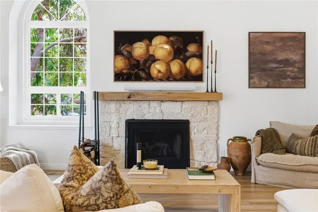 a living room with furniture a fireplace and a large window