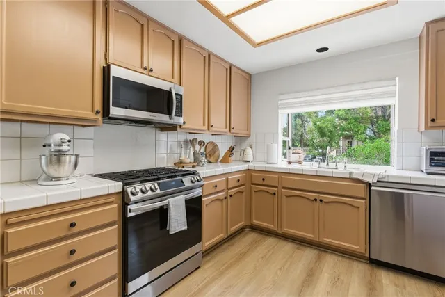 a kitchen with stainless steel appliances granite countertop a sink and stove top oven