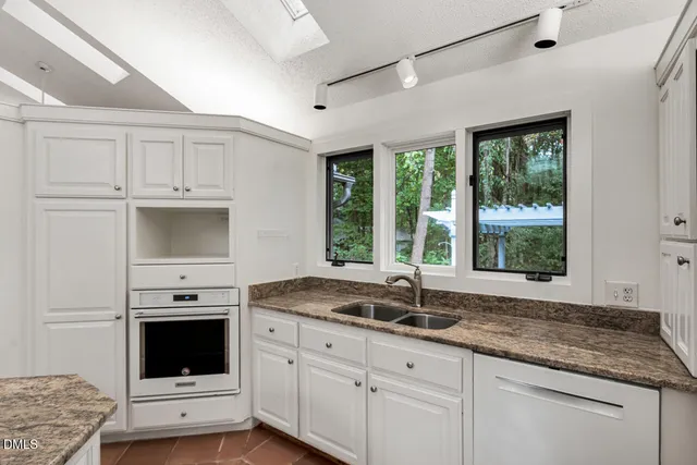 a view of an empty room with a window and ceiling fan