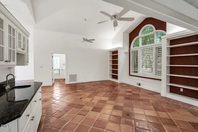 a living room with furniture a bookshelf and a large window