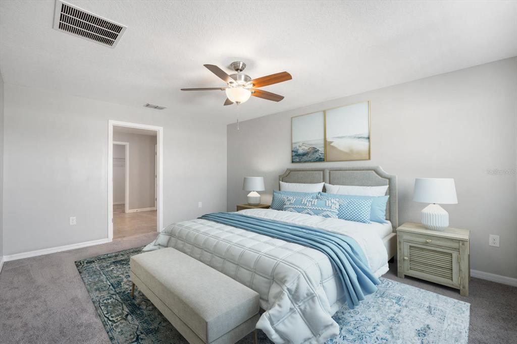 9607 Lemon Drop Loop Ruskin, FL 33573 - Photo 13 of 31 a bedroom with a bed and a chandelier