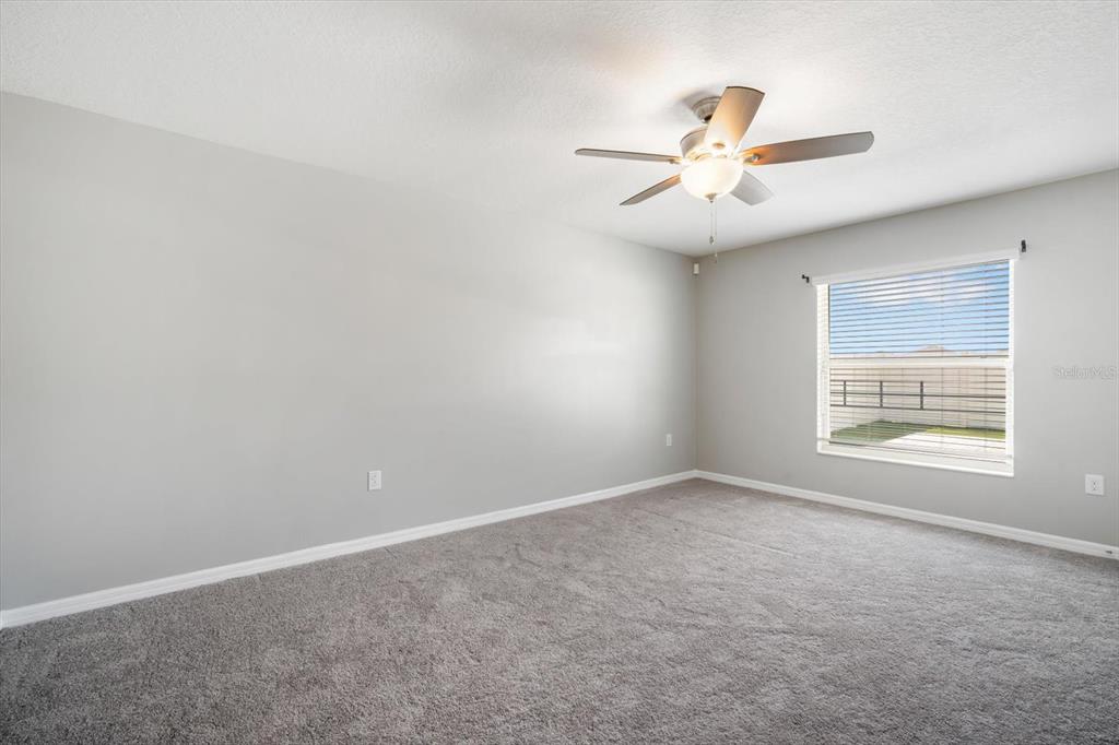 9607 Lemon Drop Loop Ruskin, FL 33573 - Photo 15 of 31 an empty room with windows and fan