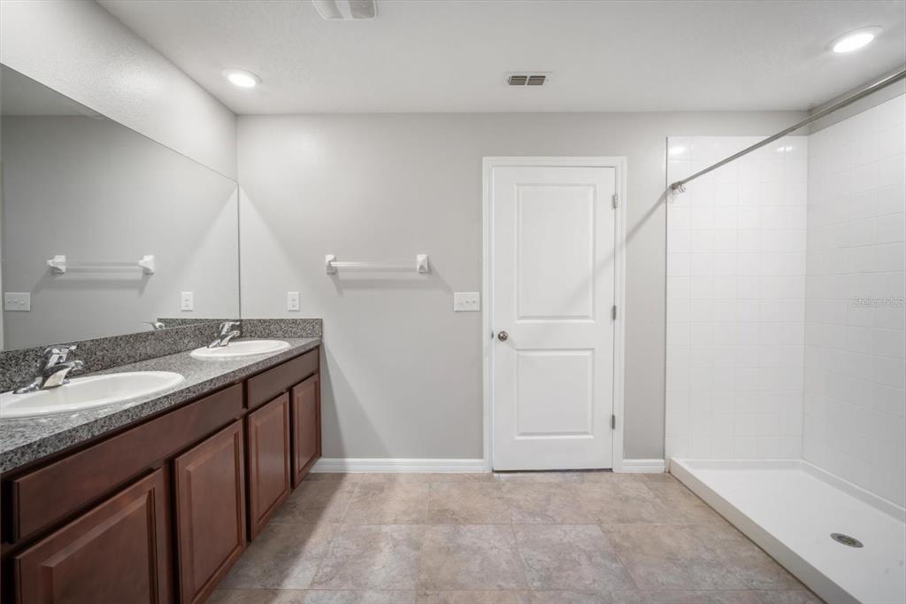 9607 Lemon Drop Loop Ruskin, FL 33573 - Photo 17 of 31 a bathroom with a granite countertop sink and a mirror