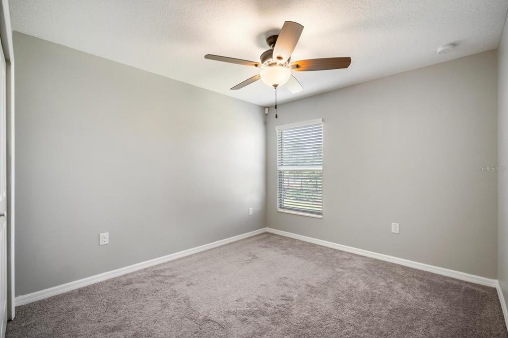 9607 Lemon Drop Loop Ruskin, FL 33573 - Photo 19 of 31 an empty room with windows and fan