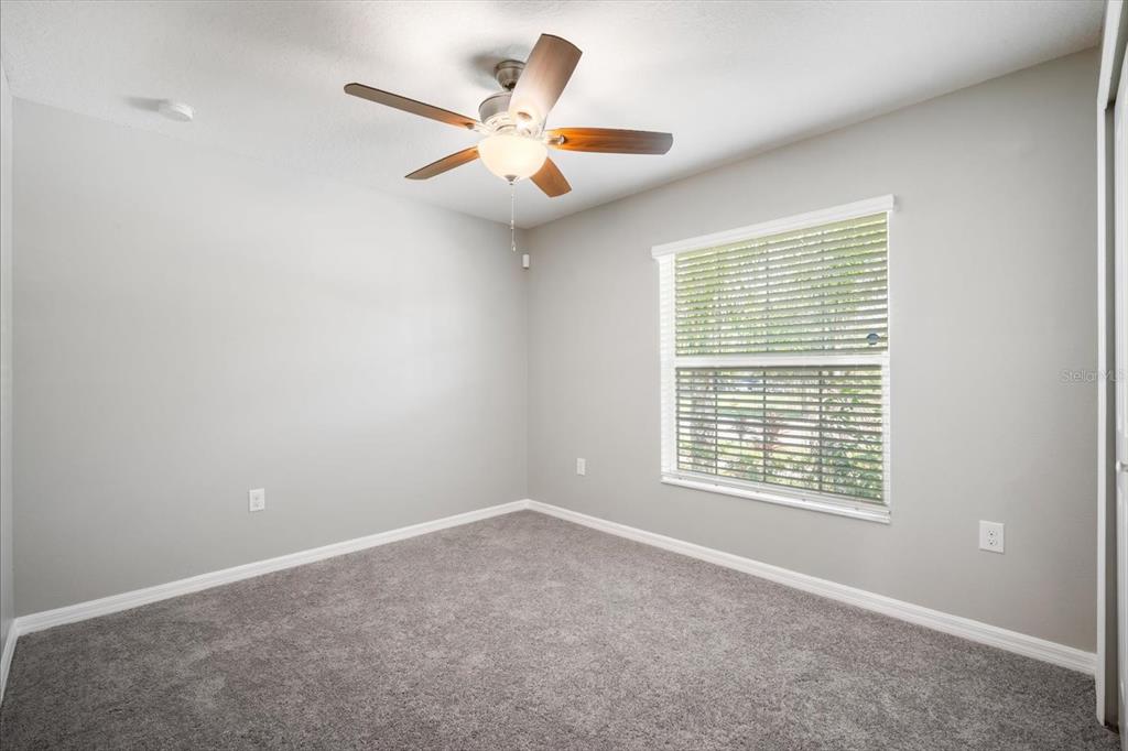 9607 Lemon Drop Loop Ruskin, FL 33573 - Photo 22 of 31 an empty room with a window and a fan