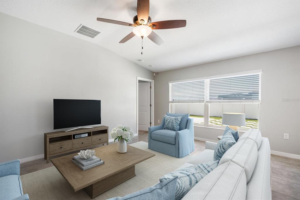 9607 Lemon Drop Loop Ruskin, FL 33573 - Photo 4 of 31 a living room with furniture a flat screen tv and a large window