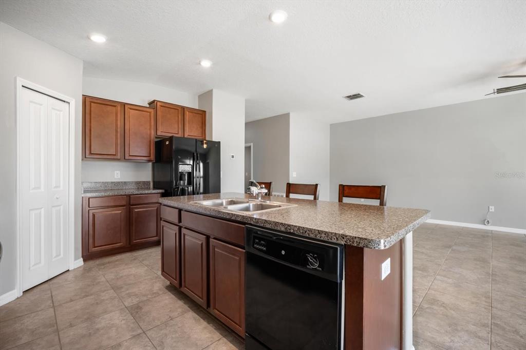 9607 Lemon Drop Loop Ruskin, FL 33573 - Photo 10 of 31 a kitchen with stainless steel appliances granite countertop a sink stove and refrigerator