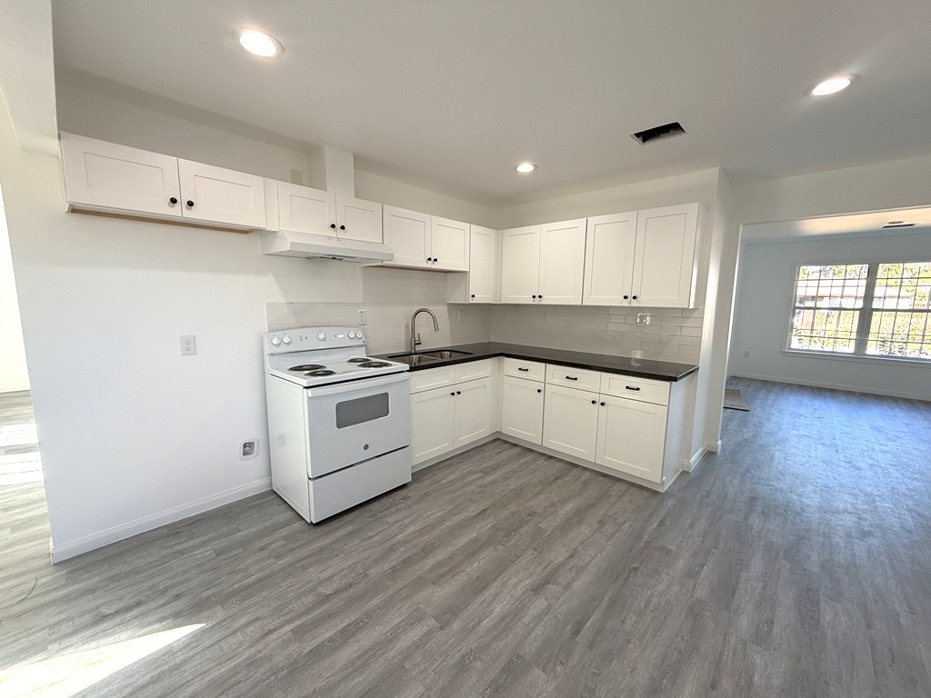 7430 Claiborne Street Houston, TX 77016 - Photo 5 of 23 a kitchen with granite countertop white cabinets and white appliances