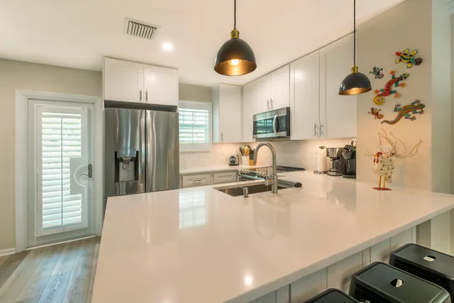 a kitchen with kitchen island a counter space a sink and appliances