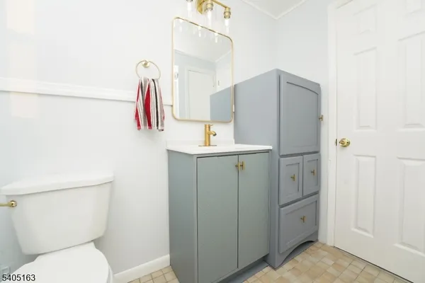 a bathroom with a sink vanity mirror and toilet