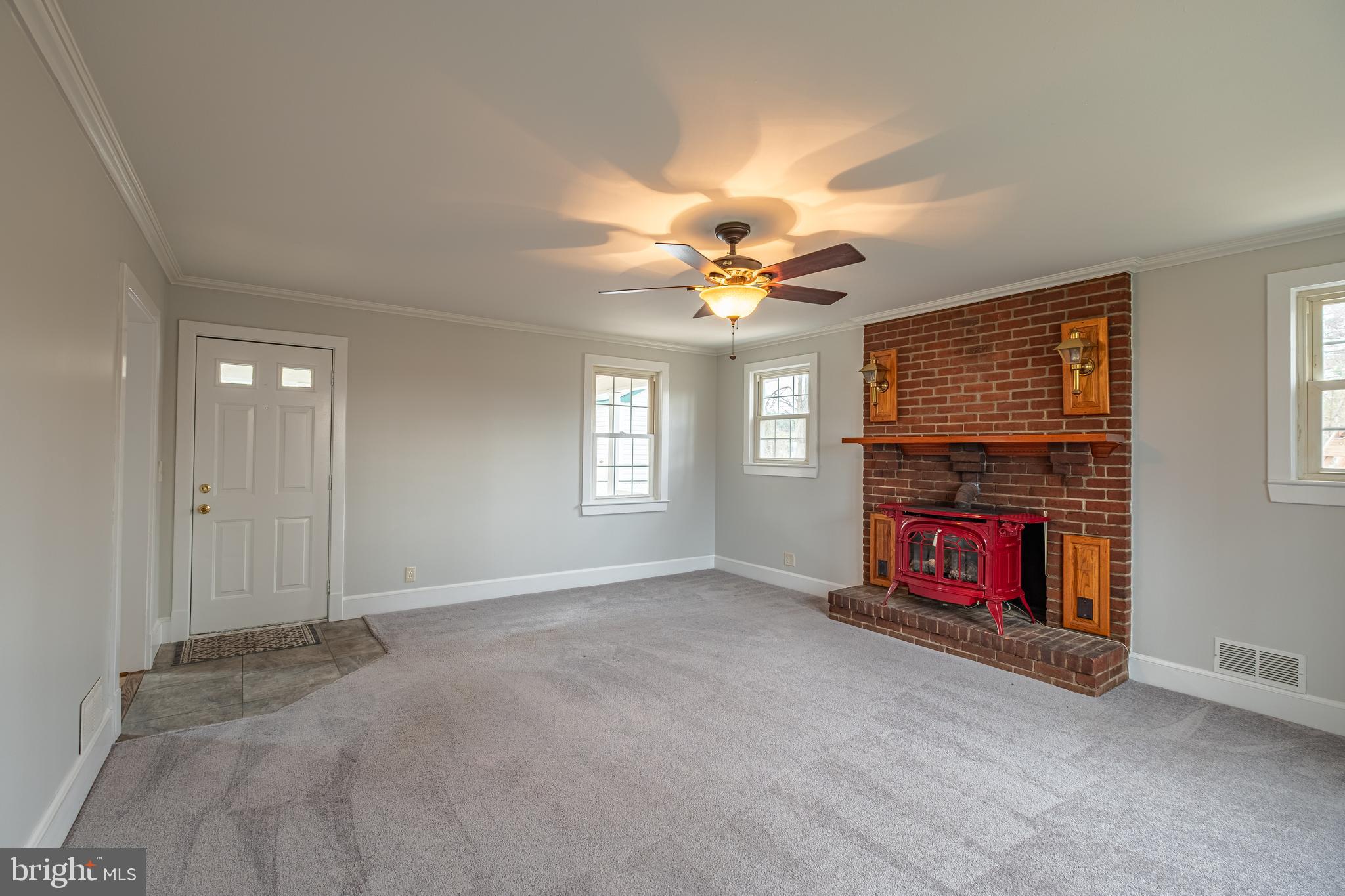 5680 Bryantown Road Bryantown, MD 20617 - Photo 5 of 33 an empty room with windows fireplace and fans