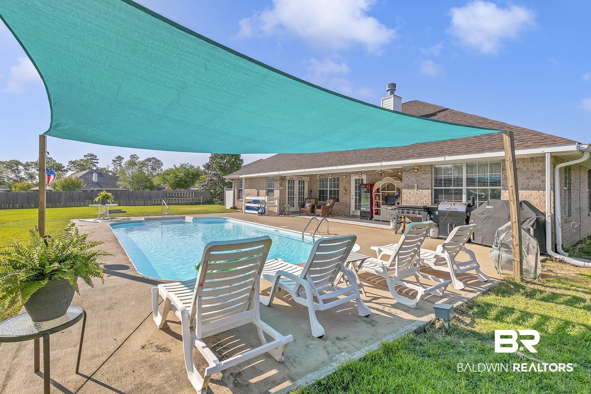 16358 Tempest Drive Foley, AL 36535 - Photo 3 of 46 View of swimming pool featuring fence, a fenced in pool, a yard, and a patio