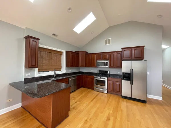 a kitchen with stainless steel appliances granite countertop a sink dishwasher stove and refrigerator