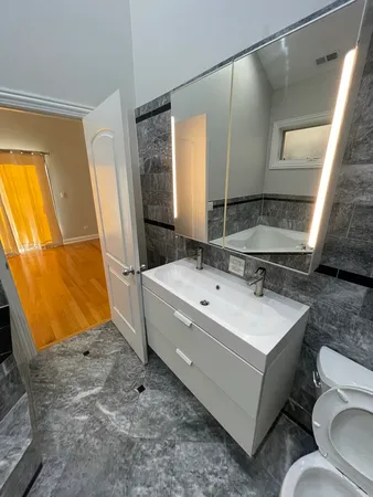 a spacious bathroom with a sink mirror vanity and toilet