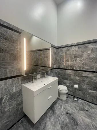 a bathroom with a sink mirror and toilet