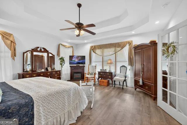 a bed room with a bed a dresser and a chandelier