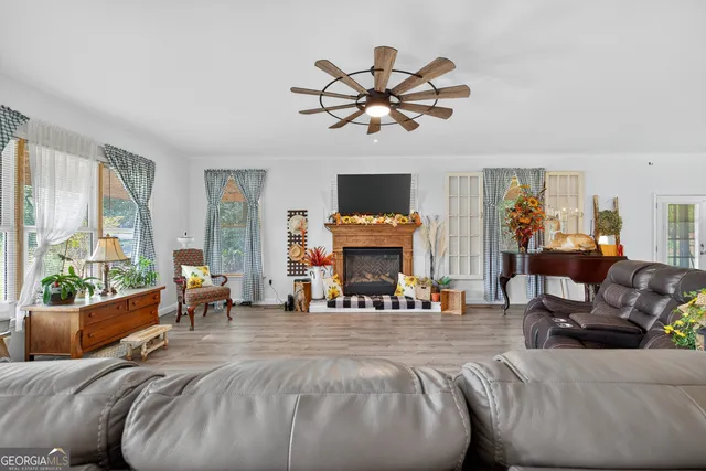 a living room with furniture a fireplace and a large window