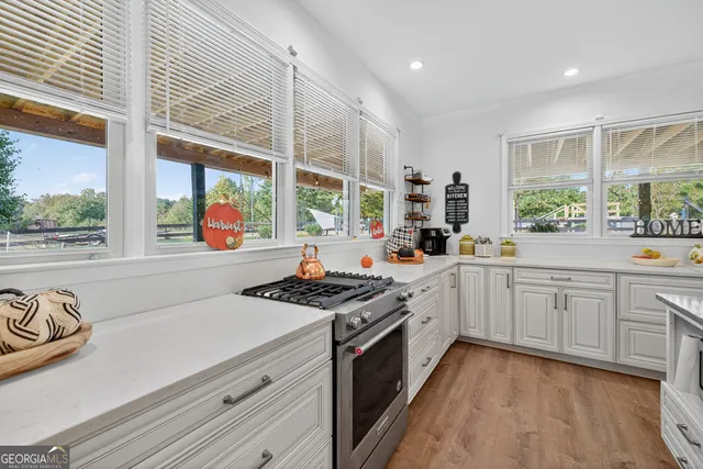 a kitchen with stainless steel appliances granite countertop a stove a sink and white cabinets