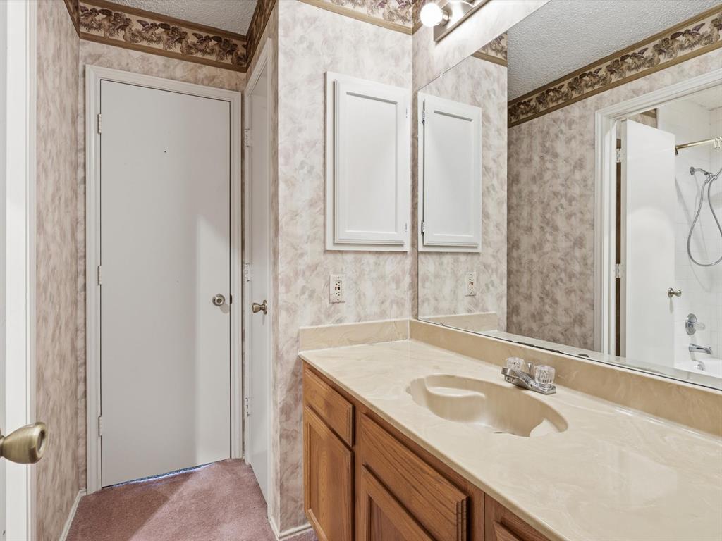 321 Gregory Lane Grand Prairie, TX 75052 - Photo 17 of 27 a bathroom with a sink and a mirror