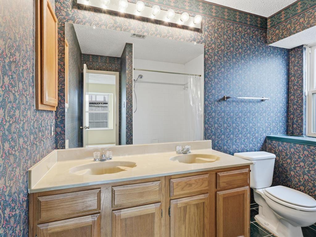 321 Gregory Lane Grand Prairie, TX 75052 - Photo 22 of 27 a bathroom with a sink and a toilet