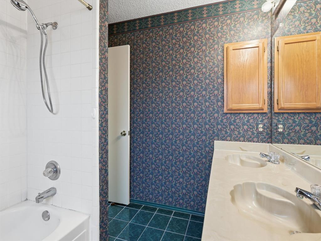 321 Gregory Lane Grand Prairie, TX 75052 - Photo 23 of 27 a bathroom with a sink a window and shower