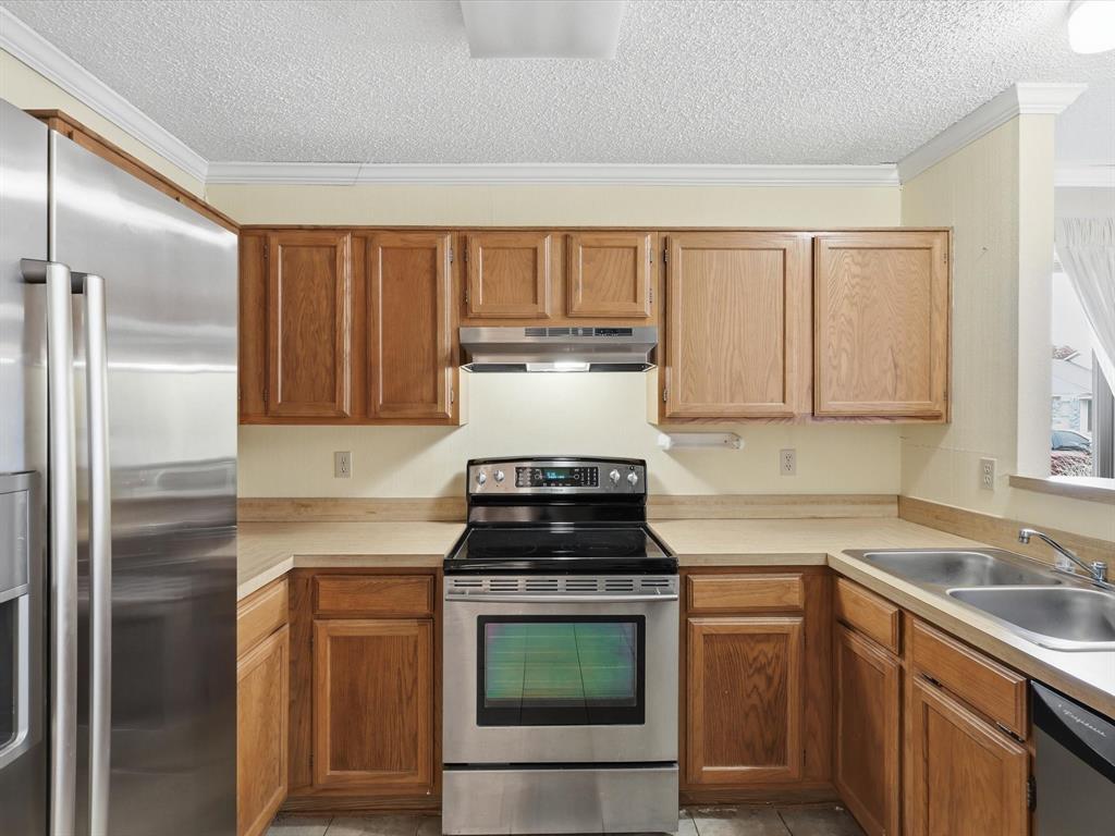 321 Gregory Lane Grand Prairie, TX 75052 - Photo 10 of 27 a kitchen with granite countertop a stove sink and cabinets
