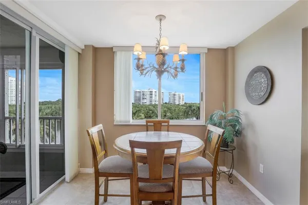 a dining room with furniture a potted plant and a chandelier