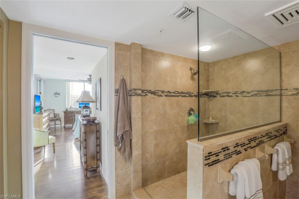 21 Bluebill Avenue, Unit B401 Naples, FL 34108 - Photo 16 of 23 a bathroom with a glass shower door and a mirror