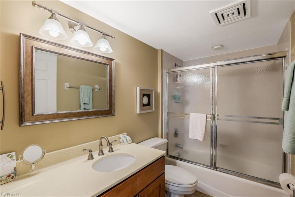 21 Bluebill Avenue, Unit B401 Naples, FL 34108 - Photo 18 of 23 a bathroom with a sink vanity granite toilet and a mirror