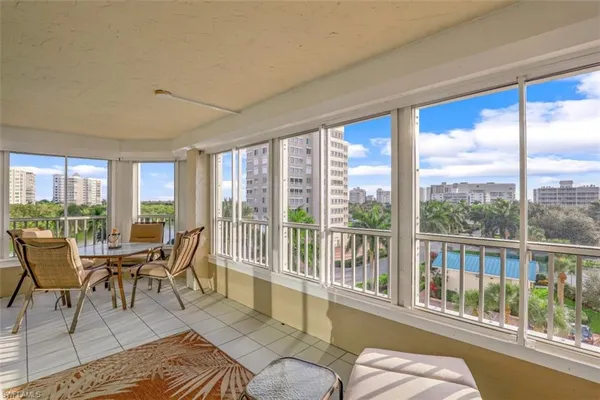 a living room with furniture and floor to ceiling windows