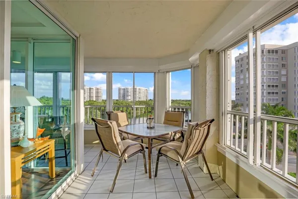 a view of a city from a dining room with furniture and floor to ceiling windows