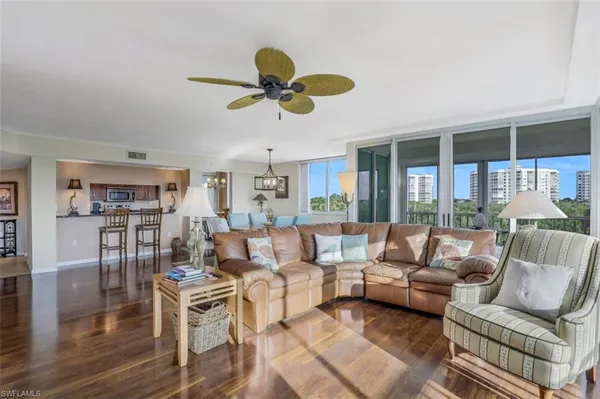 a living room with furniture a ceiling fan and a window