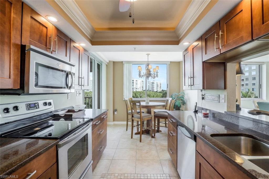 21 Bluebill Avenue, Unit B401 Naples, FL 34108 - Photo 7 of 23 a kitchen with stainless steel appliances granite countertop a sink stove and cabinets