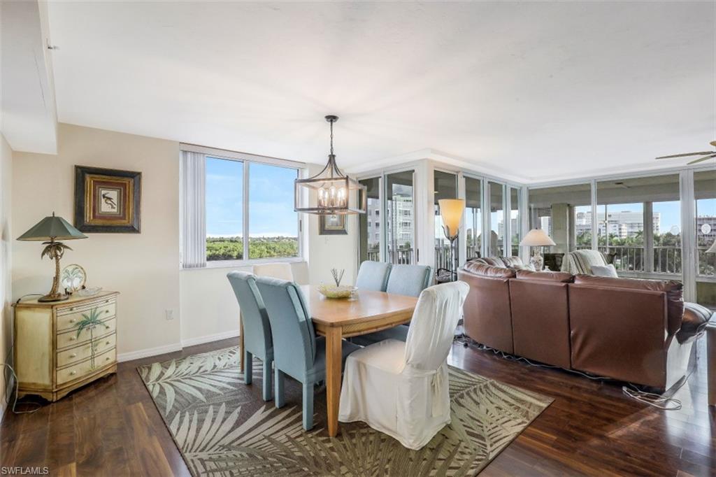 21 Bluebill Avenue, Unit B401 Naples, FL 34108 - Photo 9 of 23 a dining room with furniture a chandelier and wooden floor