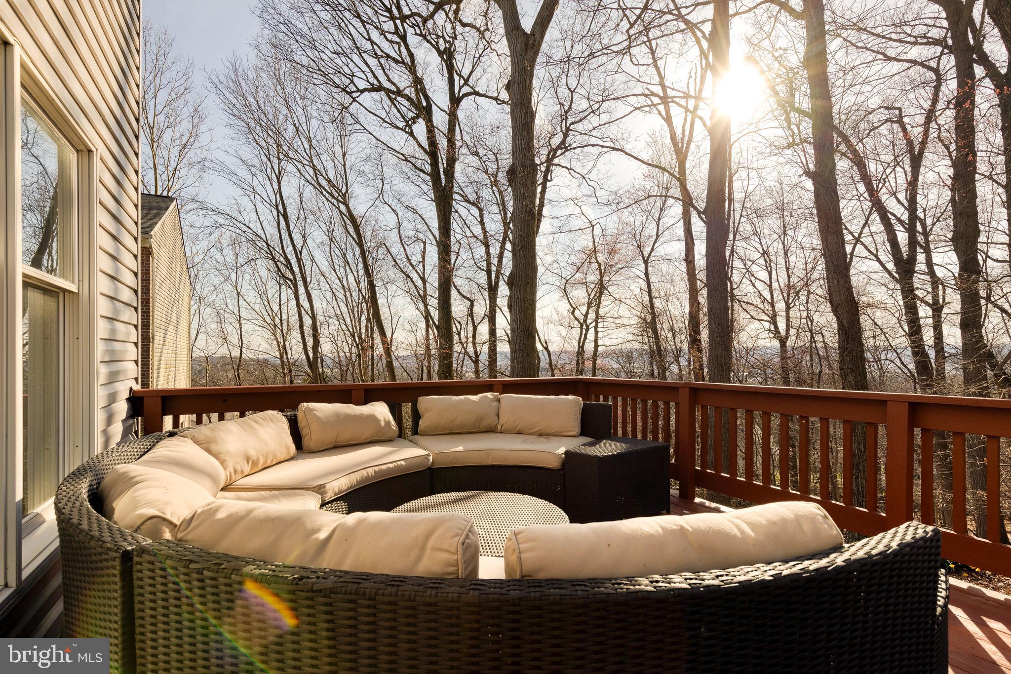a roof deck with couches and wooden fence