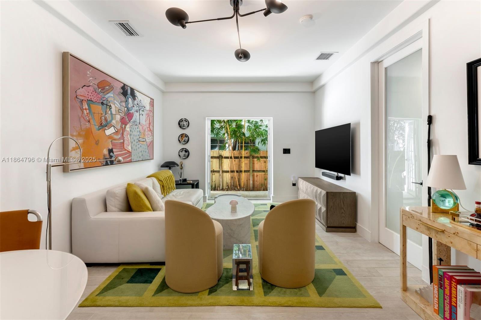 1045 Michigan Avenue, Unit B Miami Beach, FL 33139 - Photo 2 of 15 a living room with furniture and a flat screen tv