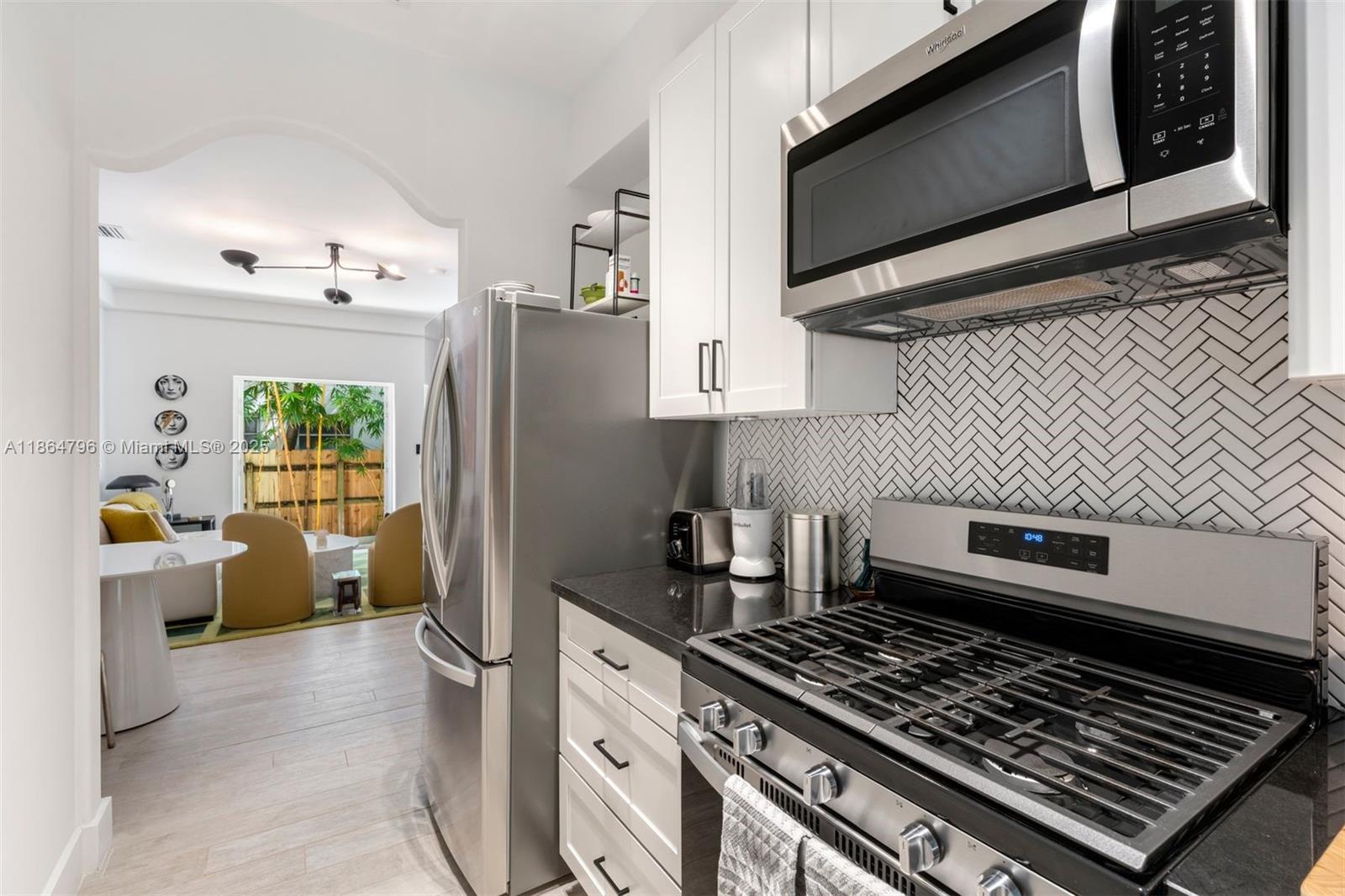 1045 Michigan Avenue, Unit B Miami Beach, FL 33139 - Photo 6 of 15 a kitchen with stainless steel appliances a stove a microwave a sink and cabinets