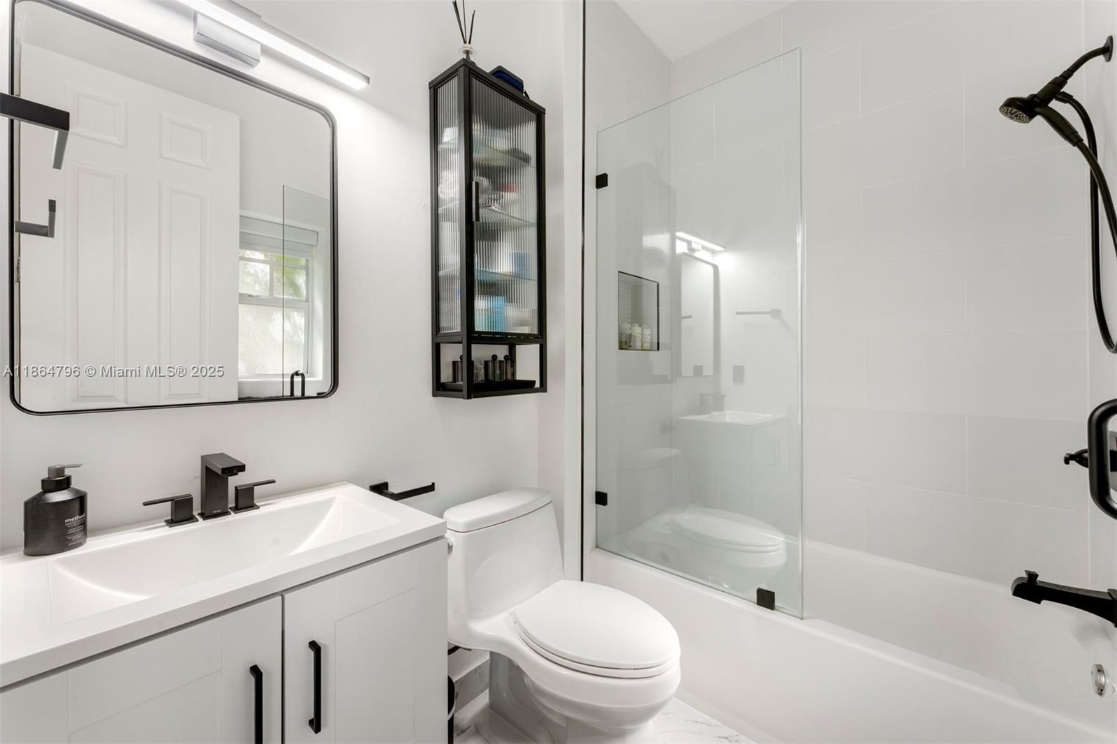 1045 Michigan Avenue, Unit B Miami Beach, FL 33139 - Photo 8 of 15 a bathroom with a sink toilet vanity and shower