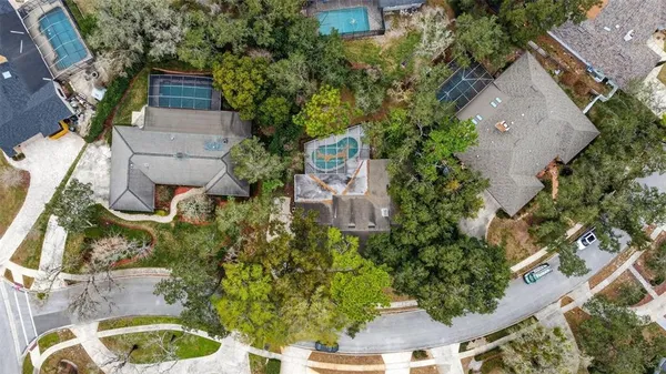 an aerial view of residential houses with outdoor space and trees