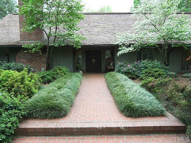 205 Beckley Court Raleigh, NC 27615 - Photo 2 of 25 Brick Paved Entry Walkway Banked by Lush Green Plantings