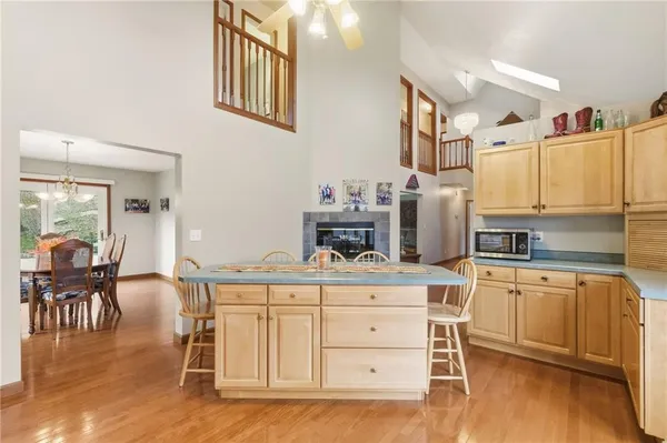 a open kitchen with stainless steel appliances granite countertop a stove refrigerator dining table and chairs