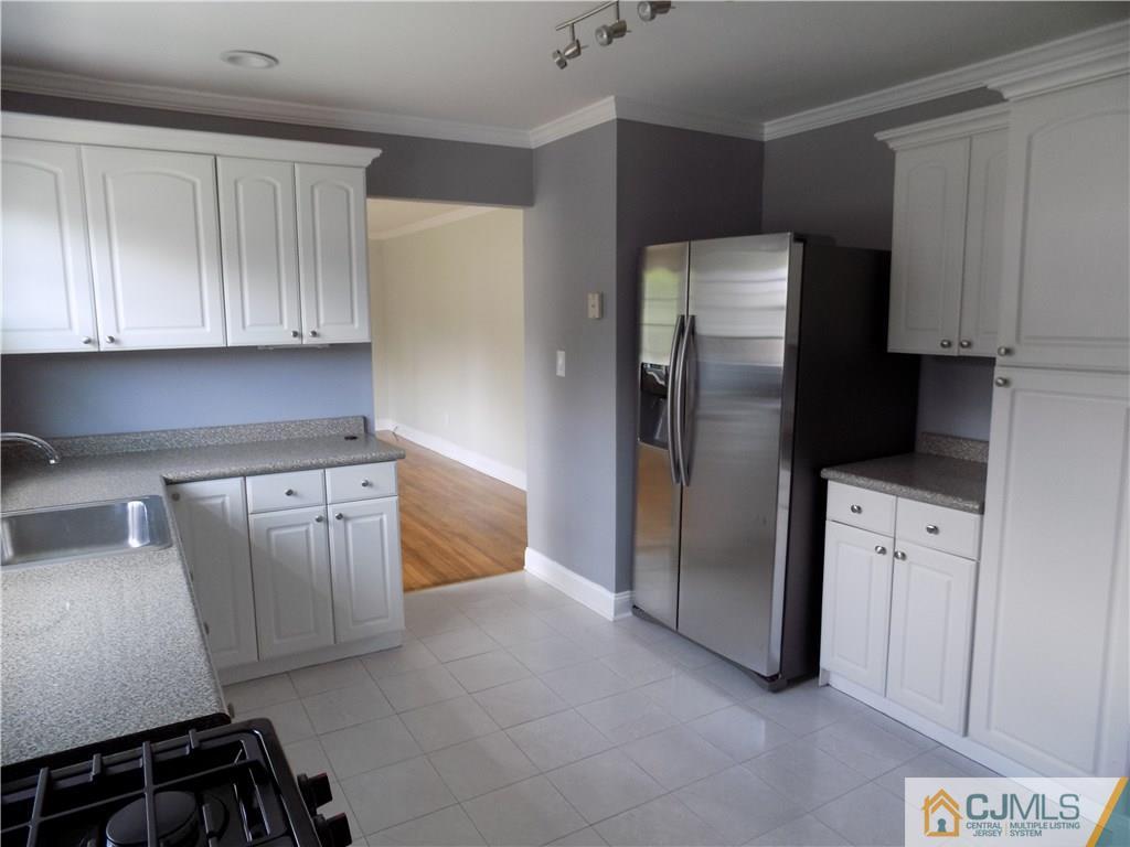 152 Orange Street Edison, NJ 08817 - Photo 5 of 23 a kitchen with stainless steel appliances granite countertop a refrigerator a stove and a sink with cabinets