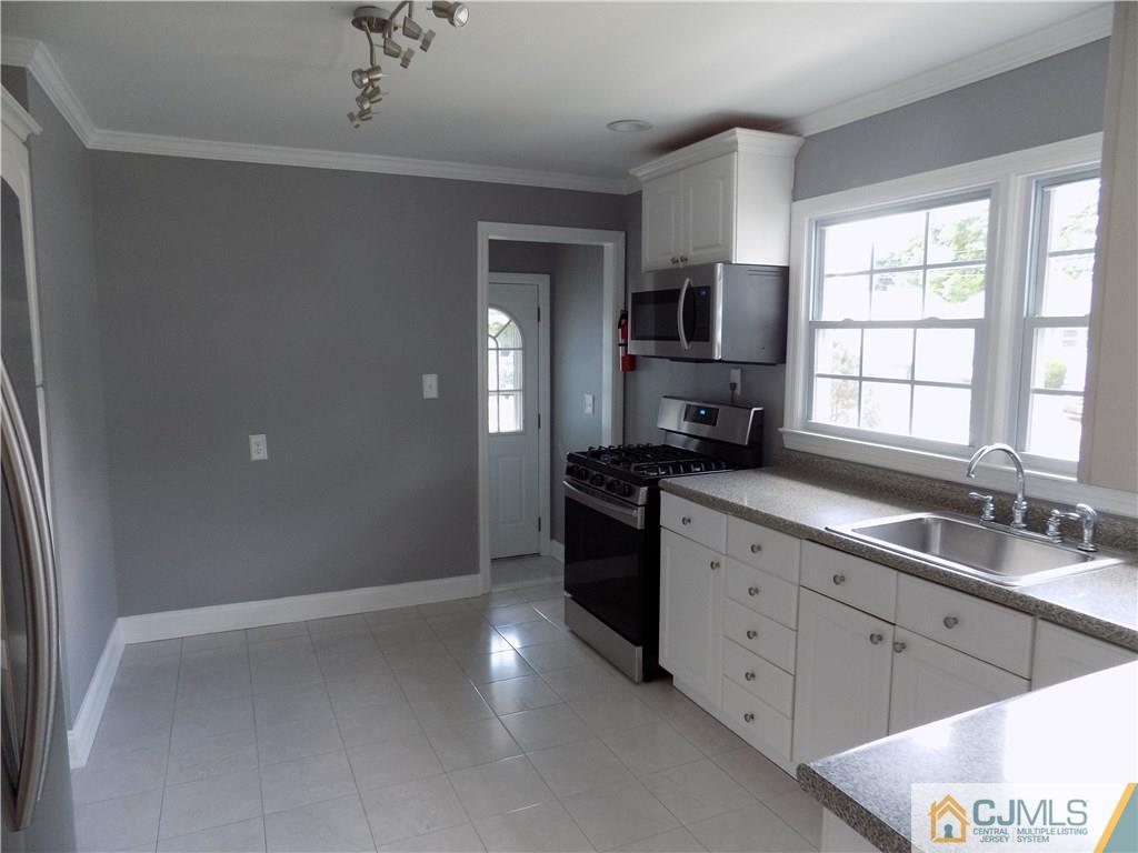 152 Orange Street Edison, NJ 08817 - Photo 6 of 23 a kitchen with a sink stove and cabinets